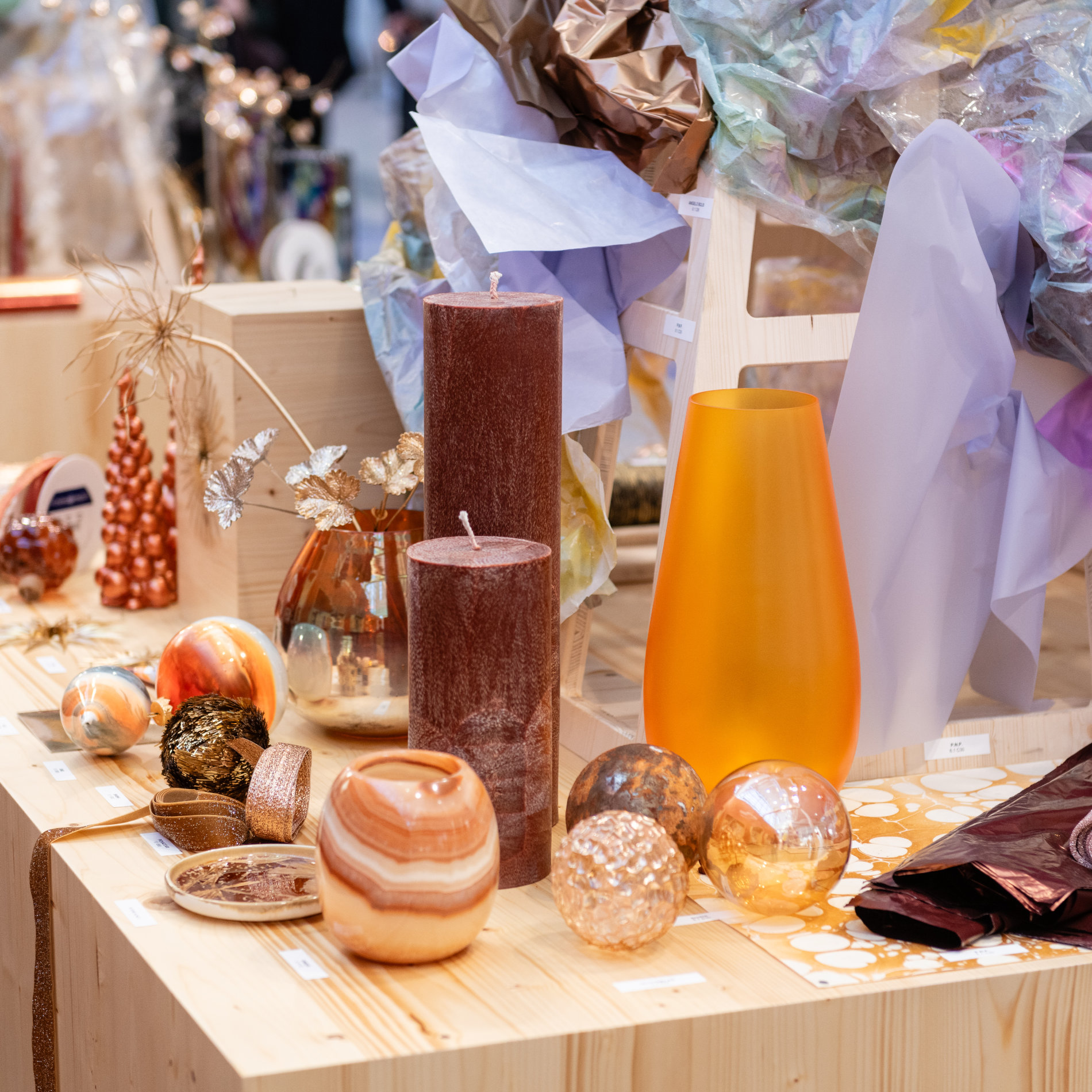 Dekoration auf der Christmasworld: Vasen, Kerzen, Kugeln auf einem Holztisch