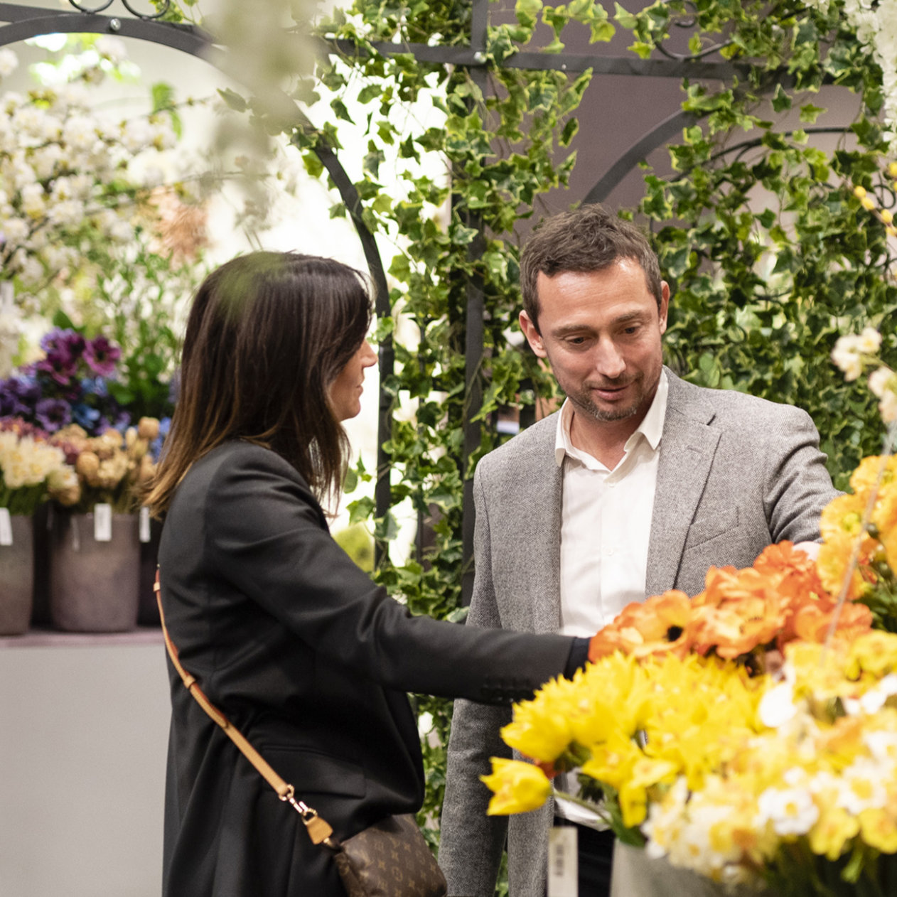 Man and woman in conversation at an exhibition stand with flowers at Christmasworld