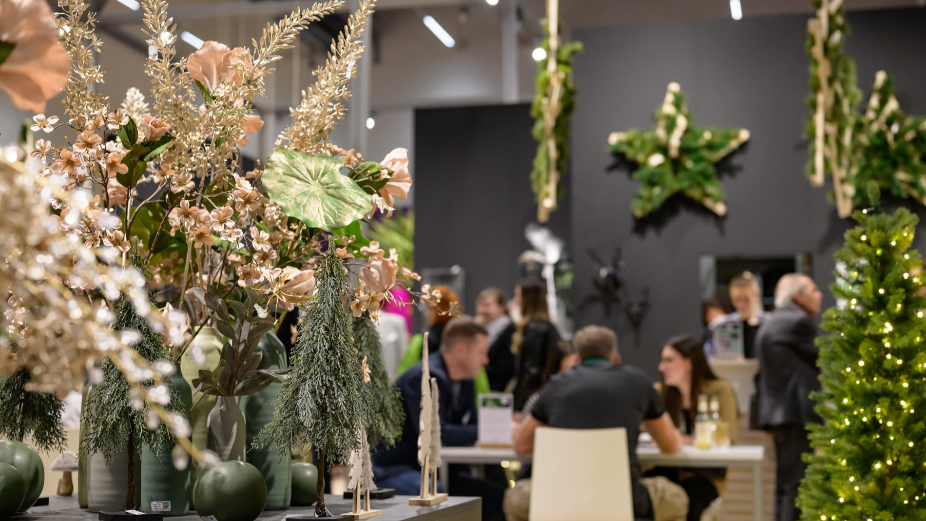 Menschen sitzen an einem Tisch umgeben von weihnachtlicher Dekoration auf der Christmasworld