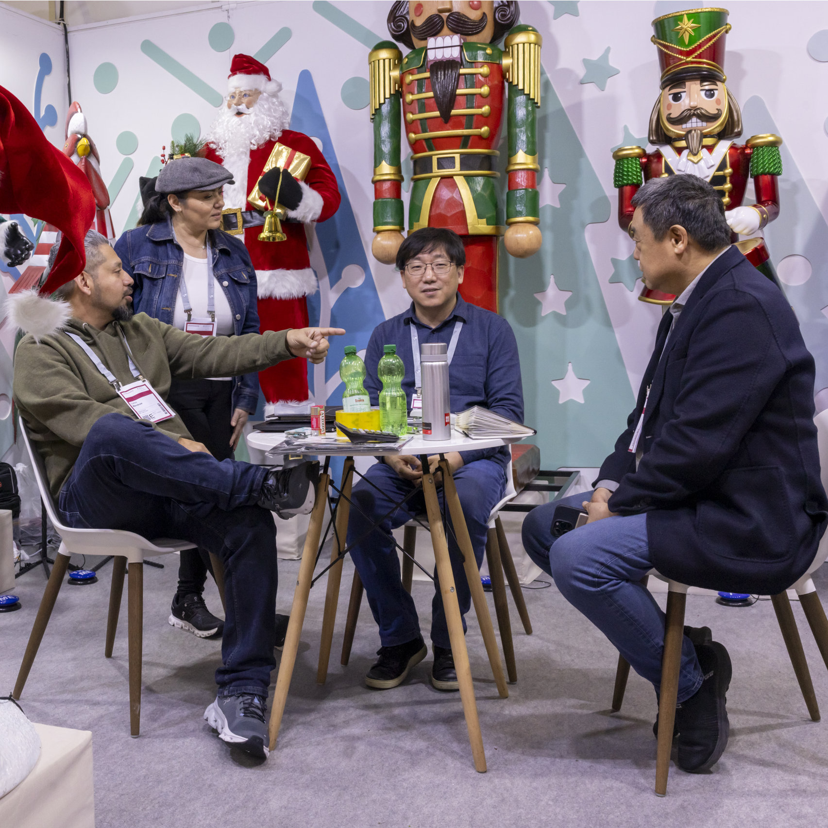 4 asiatische Personen an einem Messestand mit weihnachtlicher Dekoration auf der Christmasworld