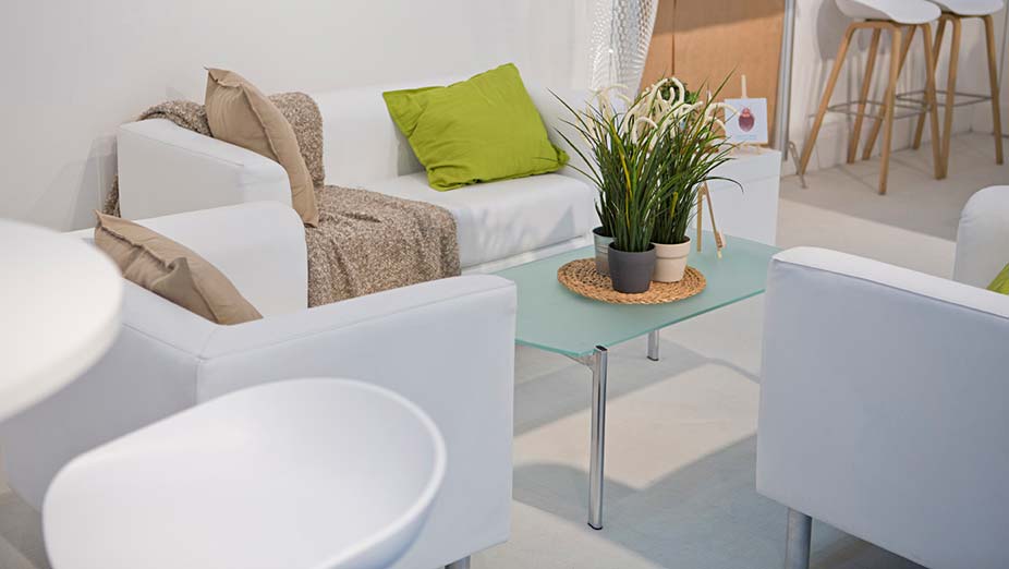 Mietmöbel & Ausstattung: Weißes Sofa mit zwei weißen Sesseln, einem Couchtisch aus Glas und weiße Sitzhocker